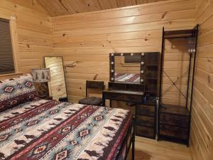 a bedroom with two beds and a vanity and a mirror at Flint Rock Cabins - The Spear in Lonsdale