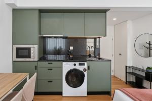 a kitchen with a washing machine in a kitchen at GuestReady - Tutti Frutti Studios in Porto