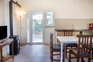 a living room with a table and a kitchen with an open door at Casetta Di Campagna Indipendente in Roccastrada