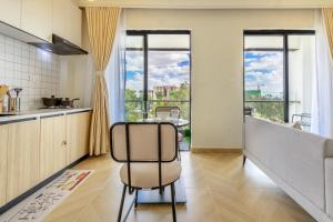a kitchen with a table and some windows at Jkia luxury Apartments in Nairobi