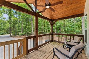 a screened porch with two chairs and a ceiling fan at Pristine, Quaint Tiny Home! The Hemlock Hideaway in Rising Fawn