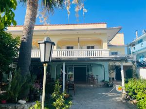 a house with a porch and a street light at Babos Holidays in Ammoudia