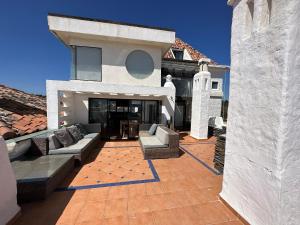 una casa con patio con sofás y sillas en Dpto en Condominio bahía de rosas - Algarrobo, en Algarrobo