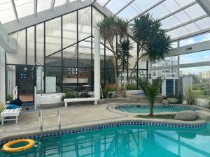 una piscina en un edificio con techo de cristal en Dpto en Condominio bahía de rosas - Algarrobo, en Algarrobo