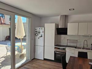 a kitchen with a white refrigerator and a table and a window at bajo independiente de casa en vigo in Vigo