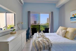 a bedroom with a white bed and a large window at Caribbean Nature Sourrounded Refuge Apartment in Juan Dolio +158 photos