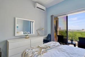 a bedroom with a bed and a dresser and a window at Caribbean Nature Sourrounded Refuge Apartment in Juan Dolio +68 photos