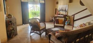 een woonkamer met rieten stoelen en een tafel bij Villaggio Lagoa Das Palmeiras in Aquiraz