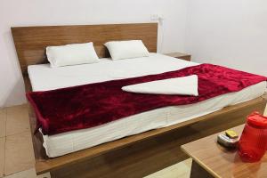 ein großes Bett mit einer roten Decke drauf in der Unterkunft OYO The 3 Star Hotel in Jabalpur + 88 Fotos