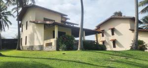 een huis met palmbomen voor een tuin bij Villaggio Lagoa Das Palmeiras in Aquiraz