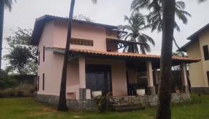 een huis met palmbomen ervoor bij Villaggio Lagoa Das Palmeiras in Aquiraz
