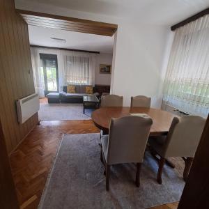 ビハチにあるVilla Behićの木製のテーブルと椅子のあるリビングルーム
