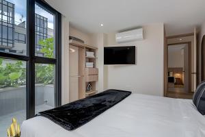 a bedroom with a white bed and a large window at Solei Loft 401 - Elegance & Comfort /AC in Poblado in El Poblado