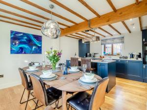 a kitchen and dining room with a wooden table and chairs at Landers Mews in Trunch +32 photos