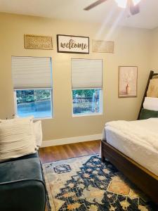 a bedroom with a bed and two windows with a welcome sign at Apple Valley Gables-Cozy mountain home with views in Hendersonville