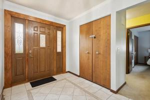 an empty hallway with wooden doors and a tile floor at Near Shopping & Dining- The South Bend Bungalow in Granger