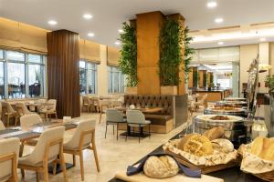 a restaurant with tables and chairs and a bakery at Radisson Blu Resort & Spa Cesme in Çeşme