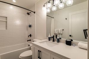 a white bathroom with a sink and a toilet at 120 Cedar Drive, Slopeside 4BR Townhome with Mountain Views & Hot Tub in Winter Park +59 photos