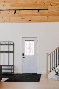 a hallway with a white door and wooden ceilings at Hidden Arbor House - newly renovated retreat in Berrien Springs