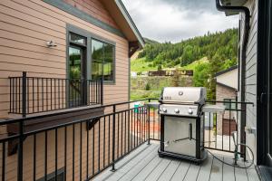 a grill on the balcony of a house at 120 Cedar Drive, Slopeside 4BR Townhome with Mountain Views & Hot Tub in Winter Park