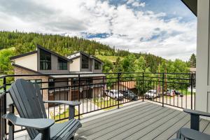 a balcony with two chairs and a house at 120 Cedar Drive, Slopeside 4BR Townhome with Mountain Views & Hot Tub in Winter Park