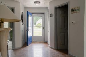 an open hallway with a blue door and a hallwayngth at Kevins Place near PawPaw Lake in Watervliet