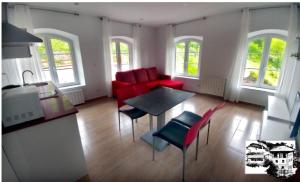 a living room with a red couch and a table at El Alba in La Lastra +2 photos