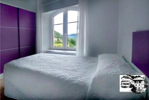 a bedroom with a white bed and a window at El Alba in La Lastra