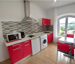 a kitchen with red cabinets and a washer at El Alba in La Lastra
