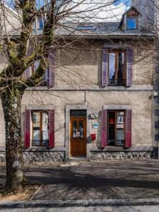 una casa con persianas rojas y una puerta en Villa Jumelia, en Le Mont-Dore