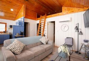 un soggiorno con un divano e un soffitto in legno di 4 Beachfront Cottages - New Bathrooms and Roofs a Lincoln Junction