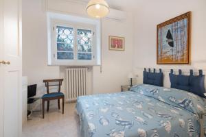 a bedroom with a bed and a chair and a window at Fiordalisi in Rapallo