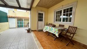 SilveiraにあるToca dos Coelhosのテーブルと椅子付きのパティオが備わる客室です。