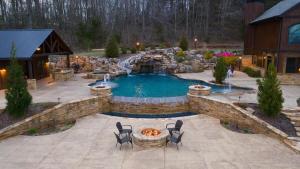 Una piscina en un patio trasero con sillas y una fogata. en Mountainside Manor l Custom pool & movie theater, en Cleveland