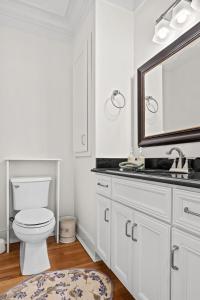 een witte badkamer met een toilet en een spiegel bij Luxury Retreat in Red Bank TN in Chattanooga