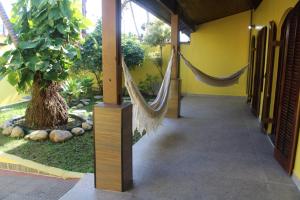 ペルイベにあるRecanto Douradoのハンモック2つと木のある部屋