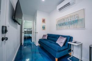 a living room with a blue couch and glass floors at Contained In Gruene -River Edition- Hot Tub in New Braunfels