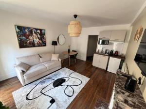 a living room with a white couch and a kitchen at La Tour Annunziata in Versailles +27 photos