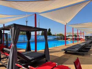 a swimming pool with lounge chairs and umbrellas at Спа-готель ПОЛО-МЕДЛАЙФ in Kremenchuk