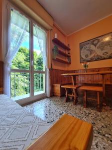 een slaapkamer met een tafel en een groot raam bij il posticino di bellagio in Civenna