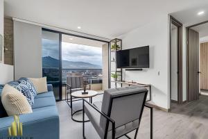 a living room with a blue couch and a tv at Class 48 apto. 1404 - Vistas modernas de la ciudad / AC in Sabaneta