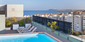 a swimming pool on the roof of a building at NH Alicante in Alicante