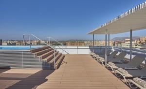 a rooftop deck with chairs and a swimming pool at NH Alicante in Alicante +37 photos