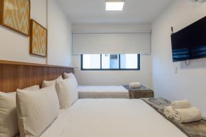 a bedroom with a white bed and a television at Studio Design 3 Apt 812 Mandi Hospitalidade in Maceió +34 photos