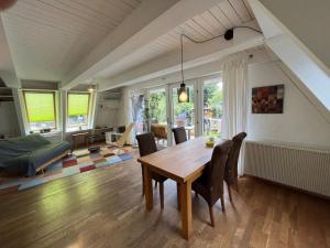 a living room with a wooden table and chairs at NurdachZeit – Ferienhaus in Schellbronn in Neuhausen