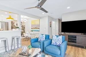 een woonkamer met blauwe stoelen en een flatscreen-tv bij Mickey's Corner in Anaheim