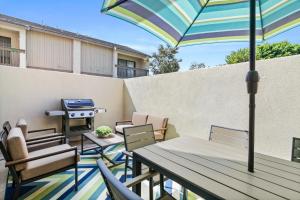een terras met een tafel en stoelen, een parasol en een barbecue bij Mickey's Corner in Anaheim