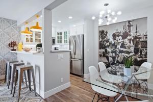 een keuken en eetkamer met een glazen tafel en stoelen bij Mickey's Corner in Anaheim