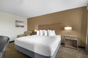 a hotel room with a large bed and a chair at Best Western Center Inn in Virginia Beach +22 photos