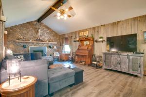 a living room with a couch and a flat screen tv at 11 Mi to Asheville Scenic Retreat with Game Room in Candler